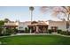 Expansive front yard featuring a well-manicured lawn and a charming home with a stone entryway at 7635 E Sweetwater Ave, Scottsdale, AZ 85260