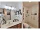 Well-lit bathroom with dark wood vanity, decorative mirror and a shower with white tile surround at 876 W El Monte Pl # 3, Chandler, AZ 85225