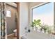 Relaxing bath featuring a tub with tile surround, plants on the window ledge, and a wooden door at 876 W El Monte Pl # 3, Chandler, AZ 85225