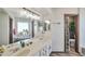 Bathroom featuring a double vanity with a decorative mirror and a window overlooking plants at 876 W El Monte Pl # 3, Chandler, AZ 85225