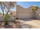 Beige stucco home featuring a two-car garage, desert landscaping, and gated entry, offering Southwestern charm and curb appeal at 8785 E Sandtrap Ct, Gold Canyon, AZ 85118
