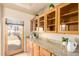 Kitchen area featuring custom wood cabinets, granite countertops, and a bright window view of the home's exterior at 8785 E Sandtrap Ct, Gold Canyon, AZ 85118