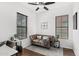 Bright living room boasts a comfortable leather sofa, large windows, and a modern ceiling fan at 9285 E Canyon Vw, Scottsdale, AZ 85255