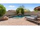 Inviting swimming pool with a stone waterfall feature, surrounded by lush landscaping and comfortable lounge chairs at 9285 E Canyon Vw, Scottsdale, AZ 85255
