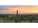 A serene backyard with lush desert landscaping and a panoramic view of the city lights at dusk at 9620 E Roadrunner Dr, Scottsdale, AZ 85262