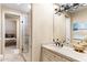 Bathroom with a granite topped vanity and a shower with glass door, providing a clean and functional space at 9620 E Roadrunner Dr, Scottsdale, AZ 85262