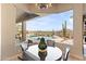 Dining room with a view of the pool and desert landscape beyond it, seen through bay windows at 9620 E Roadrunner Dr, Scottsdale, AZ 85262