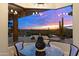 A modern dining room with floor-to-ceiling windows offers stunning views of the pool and desert landscape at 9620 E Roadrunner Dr, Scottsdale, AZ 85262
