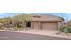 Beautiful home with a three-car garage, stone accents, and well-maintained desert landscaping at 9620 E Roadrunner Dr, Scottsdale, AZ 85262