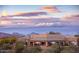Exterior view of home with desert landscape and mountain views at sunset at 9620 E Roadrunner Dr, Scottsdale, AZ 85262