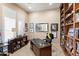 Well-appointed office featuring a wooden desk, large bookcase and bright, shuttered windows at 9620 E Roadrunner Dr, Scottsdale, AZ 85262