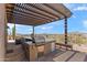 Spacious covered patio showcasing a built-in outdoor kitchen with stainless steel appliances and a bar-style countertop at 9620 E Roadrunner Dr, Scottsdale, AZ 85262