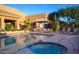 Community pool featuring lounge chairs, an umbrella shaded table, and a jacuzzi under a blue sky at 9620 E Roadrunner Dr, Scottsdale, AZ 85262