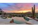 An inground pool with rock waterfall features and desert landscaping offers a relaxing retreat at 9620 E Roadrunner Dr, Scottsdale, AZ 85262