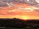 Picturesque sunset featuring vibrant orange hues and silhouetted mountains in the distance, offering breathtaking views at 9620 E Roadrunner Dr, Scottsdale, AZ 85262