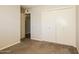 Cozy bedroom with carpet flooring, double-door closet and a view into another room for easy access at 1055 W Dragoon Ave, Mesa, AZ 85210