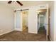 Bedroom featuring carpeted floor and a sliding barn door leading into the bathroom at 1055 W Dragoon Ave, Mesa, AZ 85210