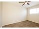 Bright, carpeted bedroom featuring a ceiling fan and natural light, creating a cozy atmosphere at 1055 W Dragoon Ave, Mesa, AZ 85210