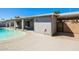 Backyard view of covered patio, gate access, and sparkling in-ground pool perfect for relaxing and entertaining at 1055 W Dragoon Ave, Mesa, AZ 85210