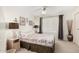 Cozy bedroom showcasing patterned bedding, bedside tables with lamps, and a window with curtains at 10855 W Buccaneer Dr, Sun City, AZ 85351