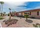 Quaint desert landscape with a decorative eagle statue, native cactus, and palm trees accenting this lovely home at 10855 W Buccaneer Dr, Sun City, AZ 85351