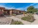 Charming single-story home featuring desert landscaping, a decorative eagle statue, and a secure gated entrance at 10855 W Buccaneer Dr, Sun City, AZ 85351