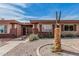 Charming single-story home featuring desert landscaping, a decorative eagle statue, and a secure gated entrance at 10855 W Buccaneer Dr, Sun City, AZ 85351