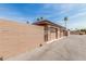 Attached one car garages with alley access are fenced with block wall and metal security gate at 10855 W Buccaneer Dr, Sun City, AZ 85351