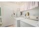 Laundry room featuring white washer and dryer units, adjacent to a white door at 10855 W Buccaneer Dr, Sun City, AZ 85351