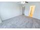 Neutral bedroom with a ceiling fan, plush carpeting, closet, and bathroom access at 1366 E Desert Fern Trl, Casa Grande, AZ 85122