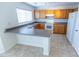 Functional kitchen featuring tile floors, wood cabinets, a breakfast bar, and white appliances at 1366 E Desert Fern Trl, Casa Grande, AZ 85122