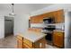 Well-lit kitchen equipped with stainless steel appliances, wooden cabinets, and a center island at 1472 E Avenida Kino --, Casa Grande, AZ 85122