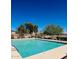 Community pool with clear blue water surrounded by mature landscaping and a black metal fence at 1472 E Avenida Kino --, Casa Grande, AZ 85122