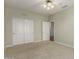 Neutral toned bedroom with carpet, a fan/light fixture, and a large sliding door closet at 15136 W Cactus Ridge Way, Surprise, AZ 85374