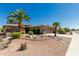 Attractive home featuring desert landscaping including gravel, rocks and mature palm trees at 15136 W Cactus Ridge Way, Surprise, AZ 85374