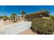 Two-car garage with desert landscaping, concrete driveway and green shrubs on a clear day at 15136 W Cactus Ridge Way, Surprise, AZ 85374