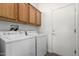 Functional laundry room with cabinets above the side-by-side washer and dryer units at 15136 W Cactus Ridge Way, Surprise, AZ 85374
