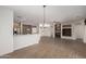 Open living room features wood-look tile flooring, a fireplace, and easy access to the kitchen at 15136 W Cactus Ridge Way, Surprise, AZ 85374