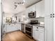 Modern kitchen features stainless steel appliances, granite countertops, and white cabinets with dark hardware at 1701 E Countrywalk Ln, Chandler, AZ 85225