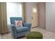 Cozy sitting area with comfortable blue chair, footstool, and sunlit window at 17620 N 17Th Pl # 36, Phoenix, AZ 85022