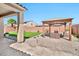 Inviting backyard oasis with well-manicured artificial turf and an elegant pergola with seating at 18394 W Lupine Ave, Goodyear, AZ 85338