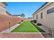 Backyard showcasing a well-maintained lawn, tidy landscaping, and a secure brick perimeter wall at 18394 W Lupine Ave, Goodyear, AZ 85338