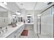 Bright bathroom features a dual sink vanity with a makeup vanity area and a glass shower at 18394 W Lupine Ave, Goodyear, AZ 85338