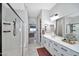 Well-lit bathroom featuring double sinks, modern fixtures, and a glass-enclosed shower at 18394 W Lupine Ave, Goodyear, AZ 85338