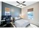 Comfortable bedroom featuring a ceiling fan, a study desk, and windows providing natural light at 18394 W Lupine Ave, Goodyear, AZ 85338
