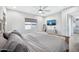 Neutral bedroom with a ceiling fan, TV, light wood accents, and ensuite bathroom access at 18394 W Lupine Ave, Goodyear, AZ 85338