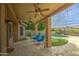 Covered patio with ceiling fans overlooking a well-maintained backyard with a pool and putting green at 1893 W Canary Way, Chandler, AZ 85286