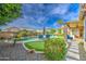 Lush backyard featuring a sparkling pool, putting green, mature landscaping, and comfortable seating areas at 1893 W Canary Way, Chandler, AZ 85286