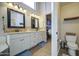 Bathroom featuring double sinks, white cabinets, granite countertops, and wood-look tile flooring at 1893 W Canary Way, Chandler, AZ 85286