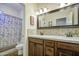 Bathroom showcasing a dual-sink vanity, decorative mirror, and a tub/shower combo with patterned shower curtain at 1893 W Canary Way, Chandler, AZ 85286